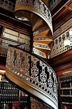 a spiral staircase in a library with bookshelves