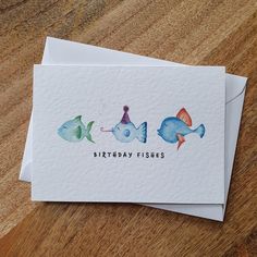 two cards with watercolor fish on them and the words birthday fishes written in black ink