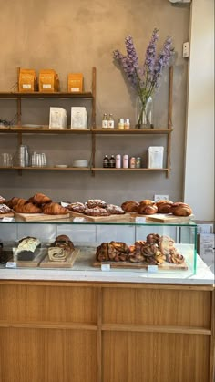 a bakery counter with breads and pastries on display in front of the counter