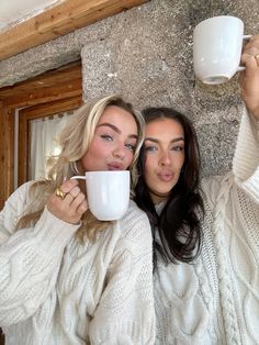 two women are holding coffee mugs in their hands and posing for the camera with their mouths open