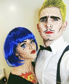 a man and woman with painted faces pose for a photo in front of a wall