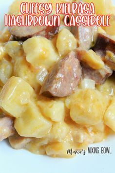 a white plate topped with macaroni and cheese covered in sausages, potatoes and mushrooms