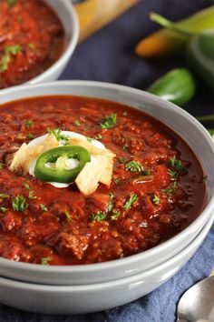 two bowls filled with chili and tortilla chips