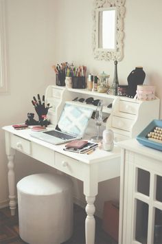 a white desk topped with a laptop computer and lots of crafting supplies on top of it