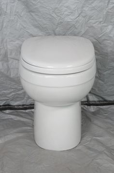 a white toilet sitting on top of a gray sheet