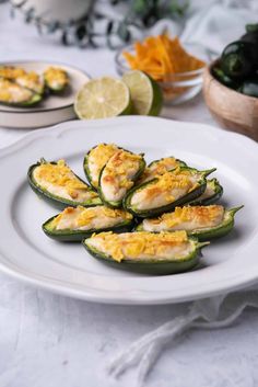 stuffed jalapenos on a white plate with limes and other ingredients in the background