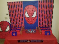 a spiderman themed birthday party with red table cloths and blue napkins on it