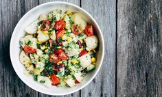 a white bowl filled with vegetables on top of a wooden table