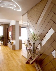 a living room with wooden floors and white walls, along with a staircase leading up to the second floor