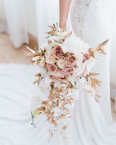 a bridal holding a bouquet of white and pink flowers