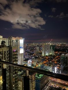 the city is lit up at night with clouds in the sky