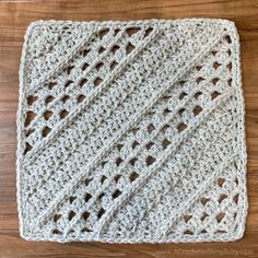 a crocheted dishcloth sitting on top of a wooden table