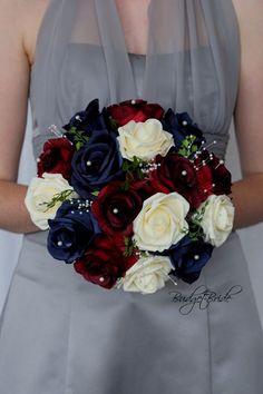 a bride holding a bouquet of red, white and blue flowers