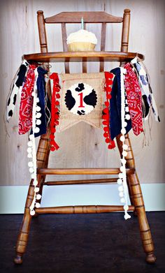 a wooden rocking chair with a red, white and blue blanket hanging from it's back