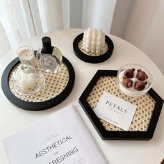 three trays with food on them sitting on top of a table next to a book