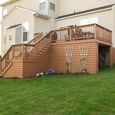 a house with stairs leading up to the second floor and another building in the background