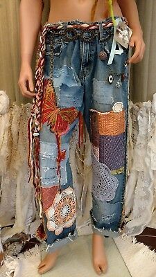 a mannequin is dressed in jeans with patches and chains on the bottom part