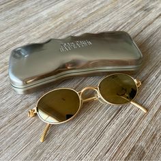 Jean Paul Gaultier Vintage Gold Sunglasses From The 90s Bought In Europe In The Airport Really Good Condition Such Cute And Unique Sunglasses 56-7113 Lens: Solid Grey Frame Color: Matte Gold Style: Round Year: 1990s Made In Japan Measurements Provided From Online Lens Width: 45mm (1.77in) Overall Frame Height: 39mm (1.52in) Overall Frame Width: 135mm (5.32in) Arm Length: 132mm (5.18in) Bridge Width: 24mm (0.95in) Comes With Case Which Is In Used Condition Retro Gold Sunglasses With Glass Lenses, Vintage Gold Aviator Sunglasses With Uv Protection, Vintage Gold Sunglasses With Polarized Lenses, Vintage Gold Sunglasses With Uva Protection, Jean Paul Gaultier Vintage, Jean Paul Gaultier Sunglasses Vintage, In The Airport, Unique Sunglasses, Grey Frame