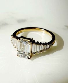 a diamond ring sitting on top of a white table next to a marble countertop