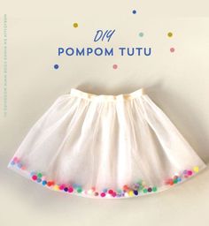 a white skirt with multicolored flowers on it and the words diy pompom tutu