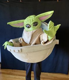 a baby yoda doll in a bathtub