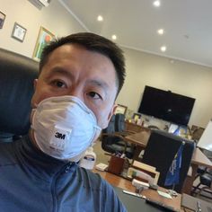 a man wearing a face mask in an office