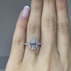 a woman's hand with a ring on it and a diamond in the middle