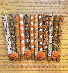 halloween candy sticks lined up with pumpkins and jack - o'- lanterns