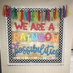 a bulletin board that says we are a rainbow of possibilities on the wall in an elementary classroom