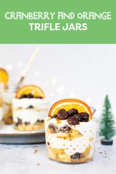 cranberry and orange trifle jars on a plate with christmas trees in the background