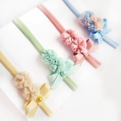 four different colored hair bows on top of a piece of paper next to each other