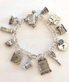 "Adorable quilting charm bracelet featuring detailed 3D pewter quilting charms and personalized initial and Swarovski birthstone on silver bracelet with toggle clasp. Ten beautifully detailed quilting charms are all 3D/two-sided pewter made in USA and lead and nickel free. Included are: thimble with heart, friendship star quilting block, Singer sewing machine, scissors, \"I Love Quilting\" block, spool of thread with needle, Dresden flower block, pin cushion, tape measure, and iron. Hand stamped Antique Silver Charms Jewelry For Anniversary, Personalized Silver Jewelry With Dangling Charms, Silver Jewelry With Dangling Charms For Personalized Gift, Antique Silver Charm Bracelet As Gift, Antique Silver Nickel-free Charm Bracelet For Gift, Silver Charm Bracelet With Lobster Clasp For Personalized Gift, Spool Of Thread, Quilter Gifts, Iron Hand