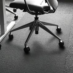 an office chair sitting on top of a carpeted floor next to a computer desk