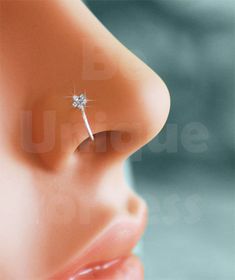 a close up of a nose with a single diamond in it's middle ear