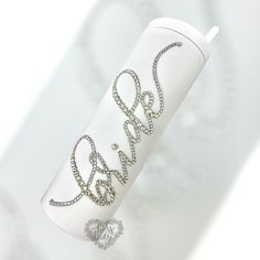 the word love is written on top of a roll of white paper with silver beads