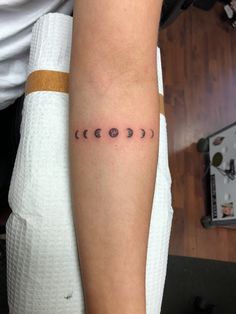 a person with a tattoo on their arm that has the sun and moon in it