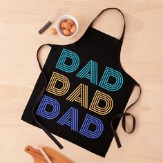 an apron with the words dad and eggs on it next to some utensils