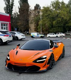 an orange sports car parked in a parking lot