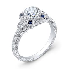 a diamond and blue sapphire engagement ring with an intricate design on the band, set in 18k white gold