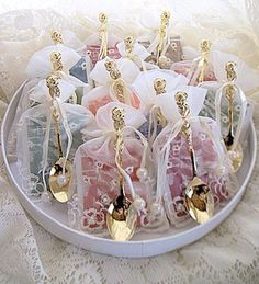 there are many small bags with spoons in them on the table, and one is filled with tea bag party favors