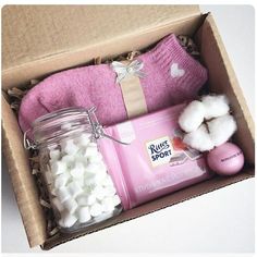 a pink box with cotton and other items in it