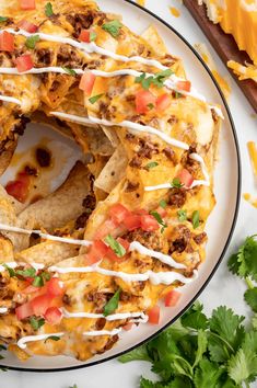 a plate topped with nachos covered in cheese and toppings