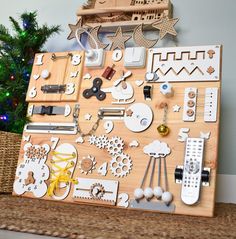 a wooden board with various items on it next to a christmas tree