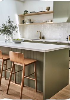 two wooden stools sit in front of an island counter with white countertop and open shelving