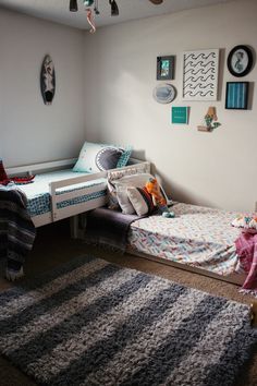 a bedroom with two twin beds and a rug on the floor in front of it