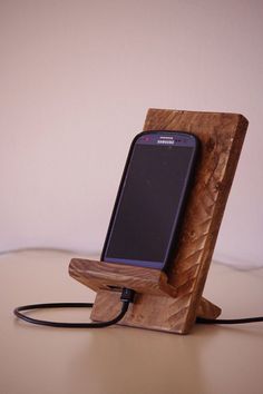 a cell phone is plugged into a wooden stand