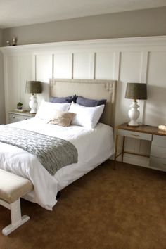 a bedroom with a large bed and two lamps on either side of the headboard