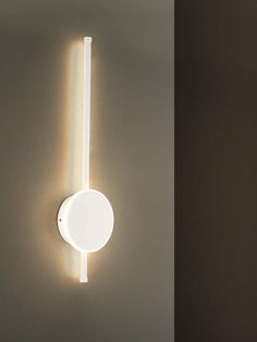 two different views of a wall light in the same room, one is white and the other is beige