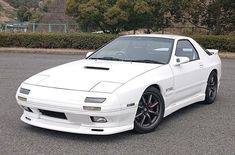 a white sports car parked in a parking lot