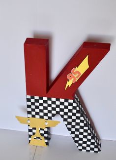 the letter k is made out of cardboard and has an image of a rocket ship on it